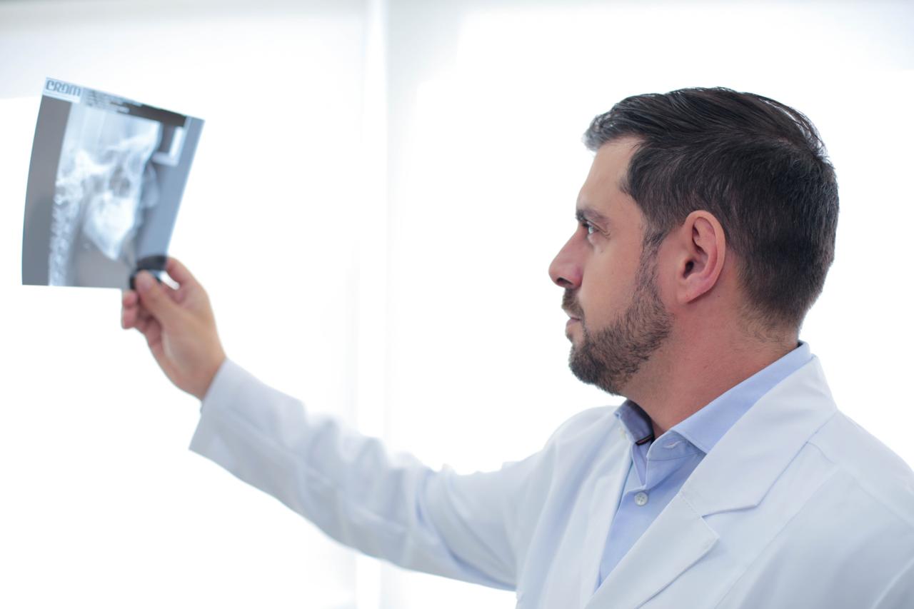 Dr. Luiz Guilherme analisando uma radiografia panorâmica